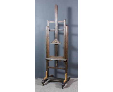 A late 19th/early 20th Century oak adjustable artist's studio easel, on trestle feet, 23ins wide x 24ins deep x 80ins high