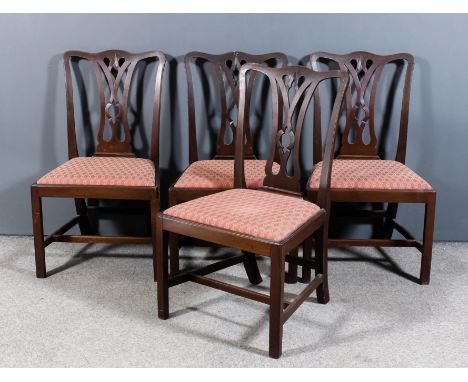 A set of four George III mahogany dining chairs of "Country Chippendale" design with shaped crest rails and fretted splats, t