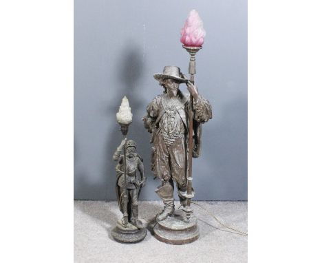 A late 19th Century spelter "Cavalier" electric lamp, the standing figure supporting a staff with tinted and moulded glass sh