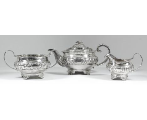 A George IV silver circular three piece tea service with floral and leaf cast mounts, floral finial and embossed with bands o