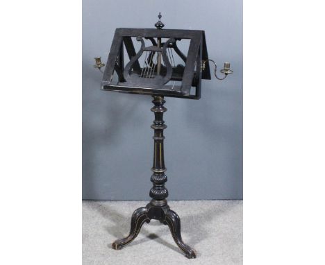 A Victorian ebonised revolving double sided music stand with turned finial to centre, adjustable fretted panels and candle sc