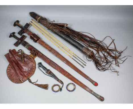 A small collection of early 20th Century Nigerian artifacts, comprising - leather quiver and cover containing three arrows, 2