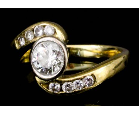 A modern 18ct gold mounted and diamond scroll pattern ring, set with central round cut stone (approximately .60ct), flanked b