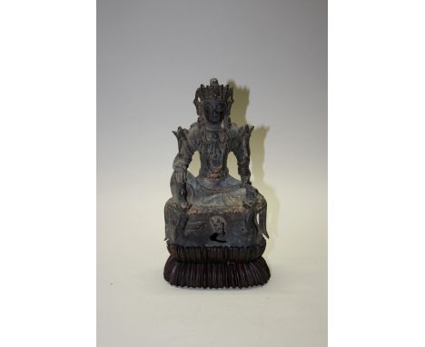 A Sino-Tibetan bronze buddha, probably 17th century, inscribed with columns of script to back, seated with right knee raised,