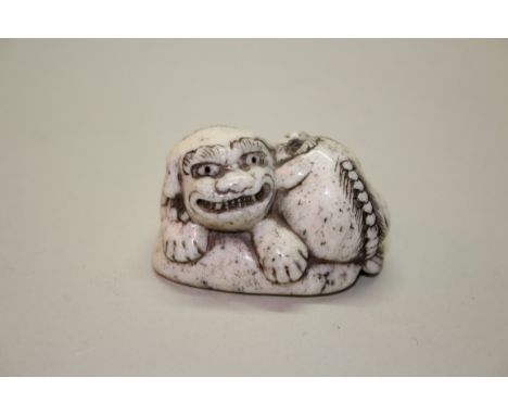 A Japanese carved marine ivory netsuke of a shishi and cub, signed Takayoshi, 19th century, 4.6cm wide.Provenance: purchased 