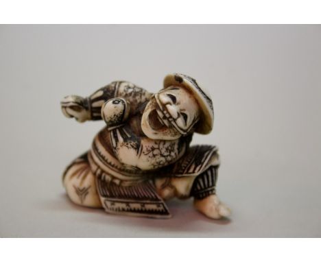 A Japanese carved ivory netsuke of a dancing man, Meiji period, 4cm wide. Condition Report: Small shallow chip to brim of hat