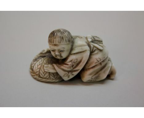 A Japanese carved ivory netsuke of a kneeling boy with a basket, Meiji period, with natural himotoshi, 4.8cm long.Provenance: