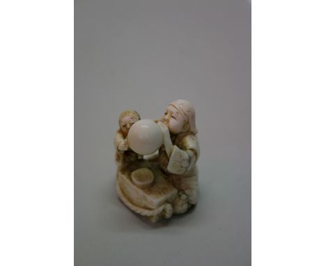 A Japanese carved ivory netsuke, signed Masatomo, with a barrell on his back, 4.2cm high, (s.d.); together with a Japanese ca