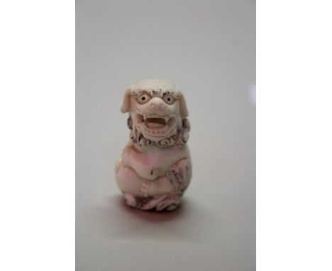 A Japanese carved ivory netsuke of a shishi and ball, signed, 4.9cm high; together with a Japanese carved ivory netsuke of a 