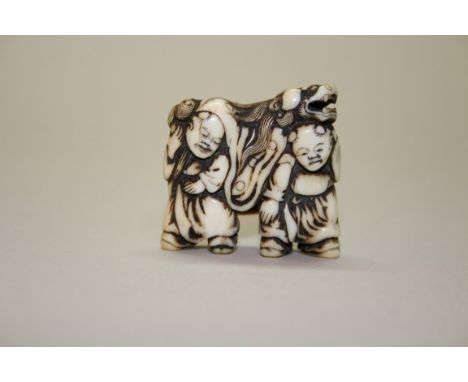 A Japanese carved ivory netsuke of Shishimai lion dancers, 18th century, depicting two young boys peering out from a mask and