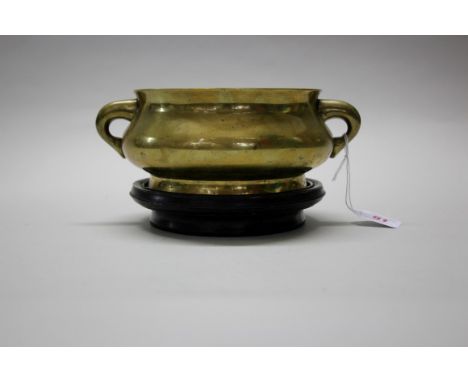 A Chinese bronze twin handled censer, Xuande six character mark, 23cm wide, 2975g, on wood stand. Condition Report:  Good, ha