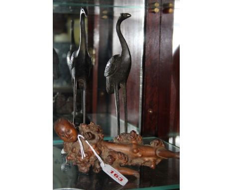A pair of Japanese bronze crane and tortoise figure groups, largest 23.5cm; together with a rootwood carving of a man, 19.5cm