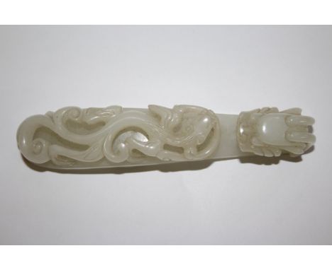 A Chinese carved white jade belt buckle, 18th/19th century, in the form of a dragon and chilong, 13cm long. Condition Report: