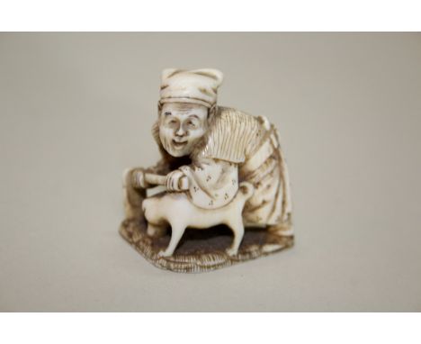 A Japanese carved ivory netsuke of a man with a hoe and a dog, signed and inscribed, 19th century, 3.5cm high.