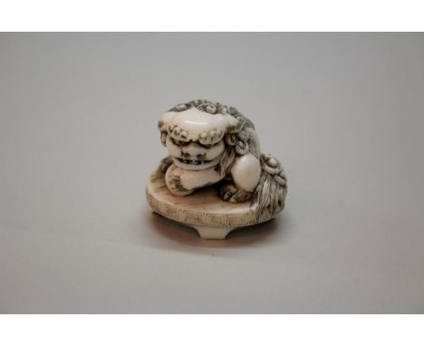 A Japanese carved ivory seal type netsuke of a karashishi, signed, Meiji period, 5cm wide.Provenance: Ashleigh House Antiques