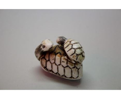 A Japanese carved bone or ivory netsuke of a two tortoises, signed, 4.2cm long; together with a Japanese carved wood netsuke 