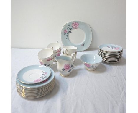 ANNIE COOPER PART TEA SERVICEdecorated with a white and pale blue ground with pink roses and gilt rims, comprising twelve cup