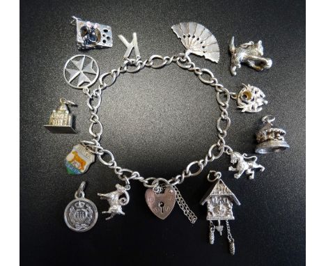 SILVER CHARM BRACELETwith silver heart padlock clasp and a large selection of mostly silver charms, some loose, including a w