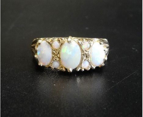 OPAL CLUSTER DRESS RINGthe three graduated oval cabochon opals separated by small round opals, on nine carat gold shank, ring