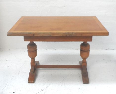 LIGHT OAK DRAWLEAF TABLEwith an oblong top with two pull out leaves, standing on bulbous supports with splayed feet united by