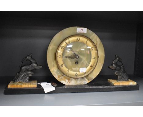 An art deco mantle clock having stone cut surround and a pair of stylised deer figures