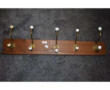 A set of brass and ceramic door or coat hooks