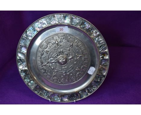 A south American wall plaque decorated with mother of pearl boarder and Aztec design