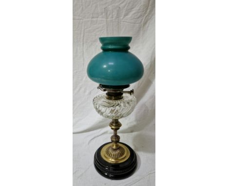A Youngs brass oil lamp with glass reservoir and green glass shade.Condition:- General wear through age and use, small crack 