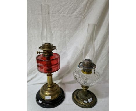 2 oil lamps to include a brass oil lamp with cranberry glass reservoir and funnel & a Messengers oil lamp with glass reservoi
