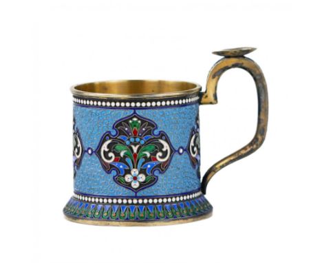 Silver and gilded glass holder of a cylindrical shape in the neo-Russian style, with a high arched handle and a saucer for re