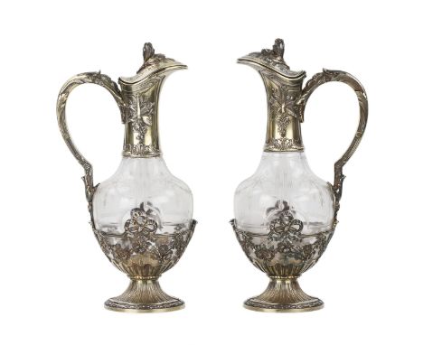 Pair of French glass wine jugs in silver. With a motif of bows and garlands on the glass and the base of the jugs. With grote