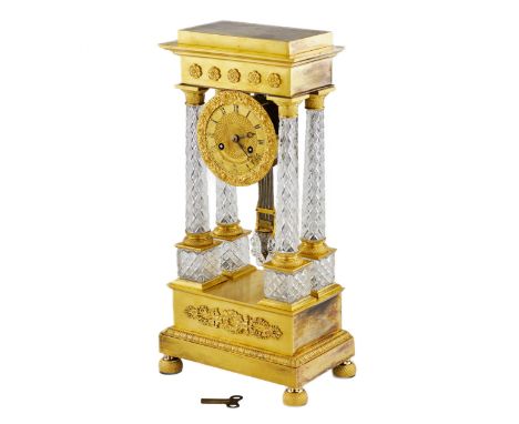 Mantel clock in Empire style model Portico Clock' made in 1830. Crystal columns frame the watch drum and connect the gold par