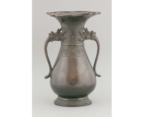 A bronze Vase, 17th/18th century, of pear shape with mask and tongue handles, and with archaic borders, the mouth petalled ag