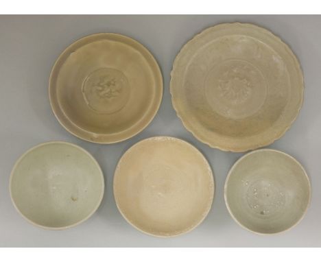 Five celadons, Ming Dynasty, a bracket rimmed dish with scrolling lotus and moulded peony, another dish with an incised prunu