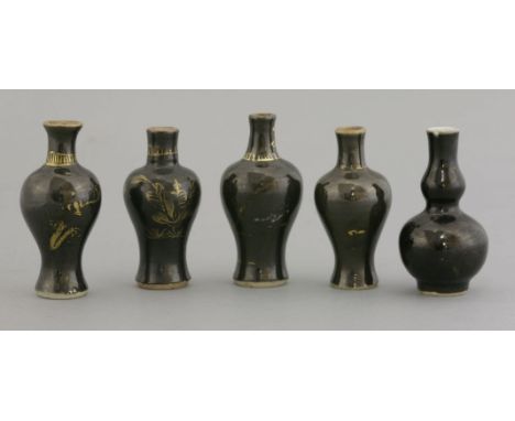 Five black-glazed 'Baby' Vases, early to mid-18th century, baluster or double gourd, the shiny black glaze gilt with flowers,