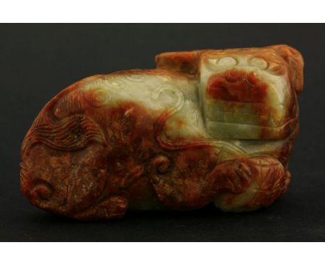 A small boulder Carving, 18th century or earlier, of a grinning Buddhist lion, fur details engraved in the toffee and celadon