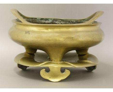 A bronze Incense Burner and Stand, late 19th century, the shallow body resting on three stub feet and with twin flying handle