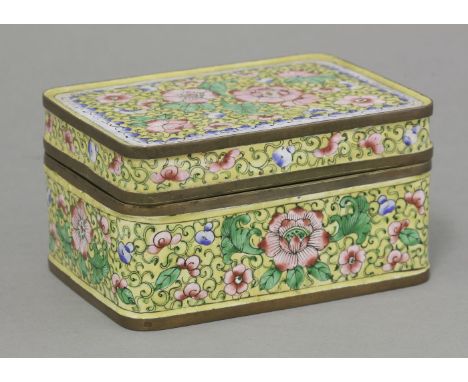 A Canton enamel Box and Cover, c.1920, enamelled all over with peonies, leaves and scrolls on a yellow ground, the interior a