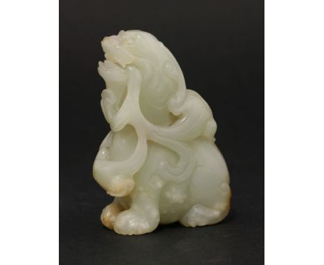 A jade mythical two-horned Beast, probably 19th century, its lion head raised with two horns and holding ruyi in its mouth, t