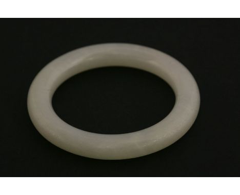 A white jade Bangle, 19th/20th century, possibly for a child, the stone a uniform colour throughout, interior 5.1cm exterior 
