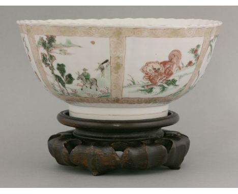 A famille verte Bowl, Kangxi (1662-1722), the fluted body decorated with panels of an iron-red Buddhist lion and a kylin, and