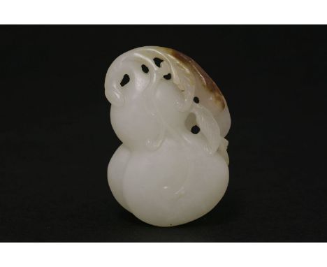 A white jade Pendant, 20th century, of a double-gourd on leafy branch, vine trailing down the fruit, the stone with brown inc