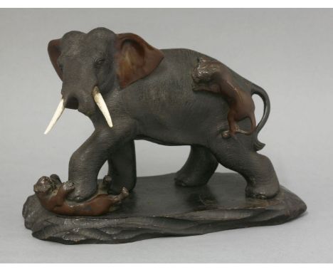 A bronze Elephant, late 19th century, the pachyderm with flailing ears and ivory tusks, a tiger on its back and another under