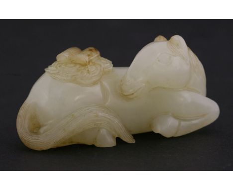 A fine white jade Horse, probably 18th century, resting with turned head, its back carrying scrolls among clouds continuing o