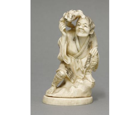 An ivory Gama Sennin, late 19th century, the immortal seated on a rock, a toad clambering over his shoulder, details black en