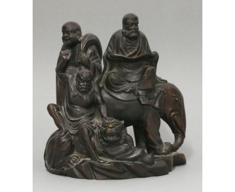 An unusual wood Group of three Buddhist Immortals, c.1900, one bearded and reading a sutra, and probably the Buddha himself, 