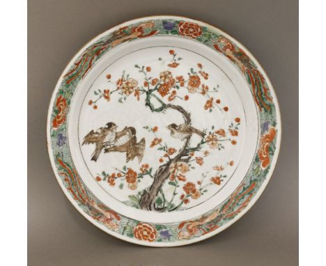 A Kangxi famille verte dish, c.1700, painted in the centre with squabbling sparrows in a prunus tree, the rim with feng, rest