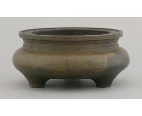 A bronze Incense Burner, possibly 18th century, the pressed onion body on three lug feet, below a sharply ringed neck, mottle