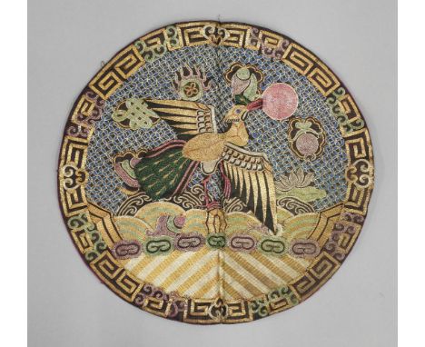 A circular Rank Badge, late 19th century, worked in brilliant coloured silks, with a peacock on a rock amongst waves (third c