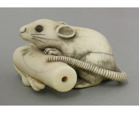 A good ivory Netsuke, first half of the 19th century, a rat peering over a fallen candle, finely incised black hair and inset